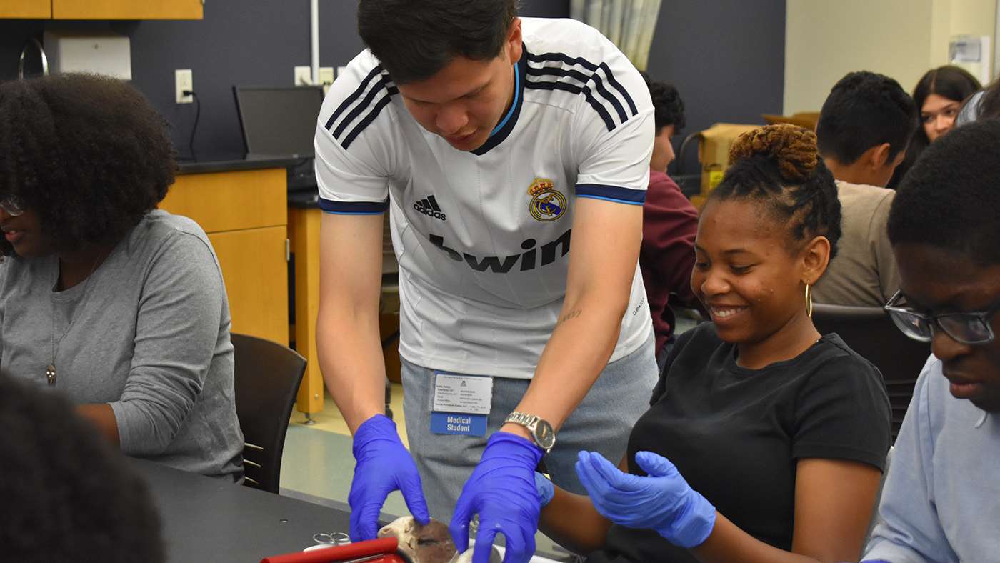 Justin Perez assisting young girl with activity