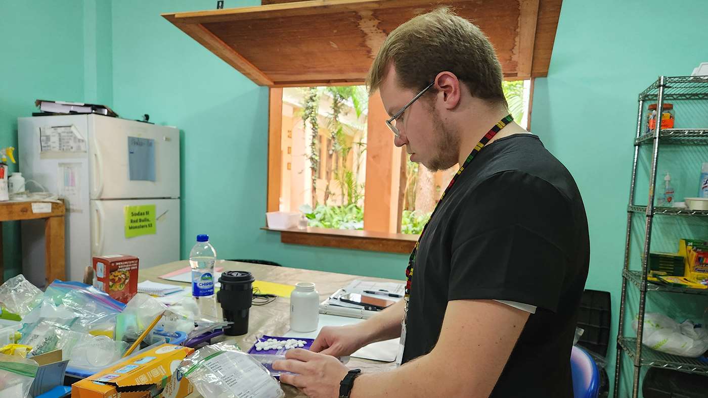 MCW pharmacy student Adam Crouse prepares a prescription in the pharmacy within the community-owned hospital in rural San Raymundo, Guatemala.