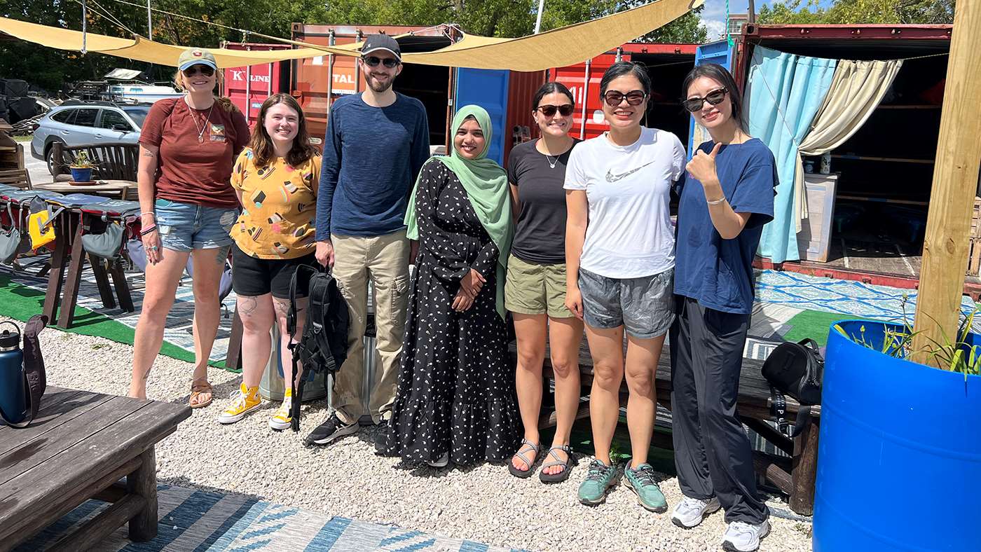 Group of people standing in front of kayaks
