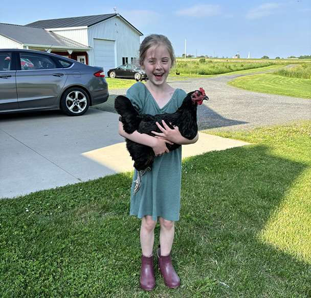 Young girl holding a chicken