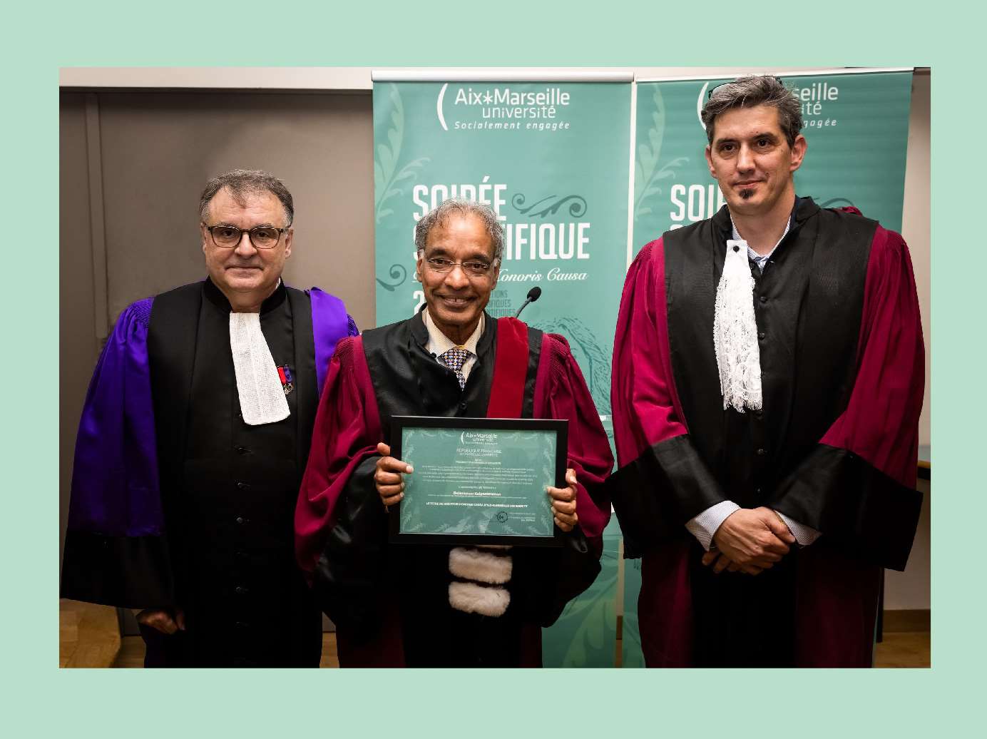 Dr. Kalyanaraman receiving an honorary degree from two individuals at Aix-Marseille University