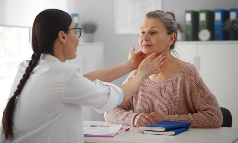 Physician Checking Thyroid of Patient