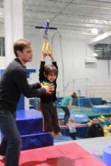 Man Assisting Child on Zip Line