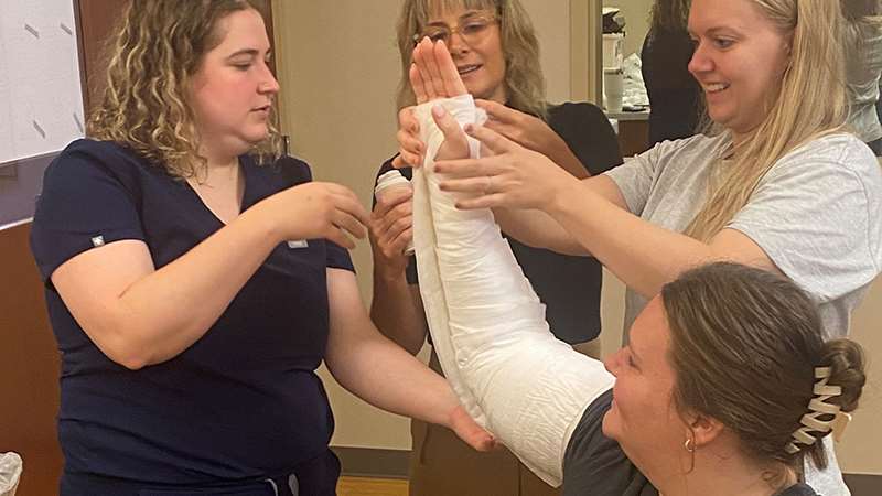 Medical professionals applying an arm cast