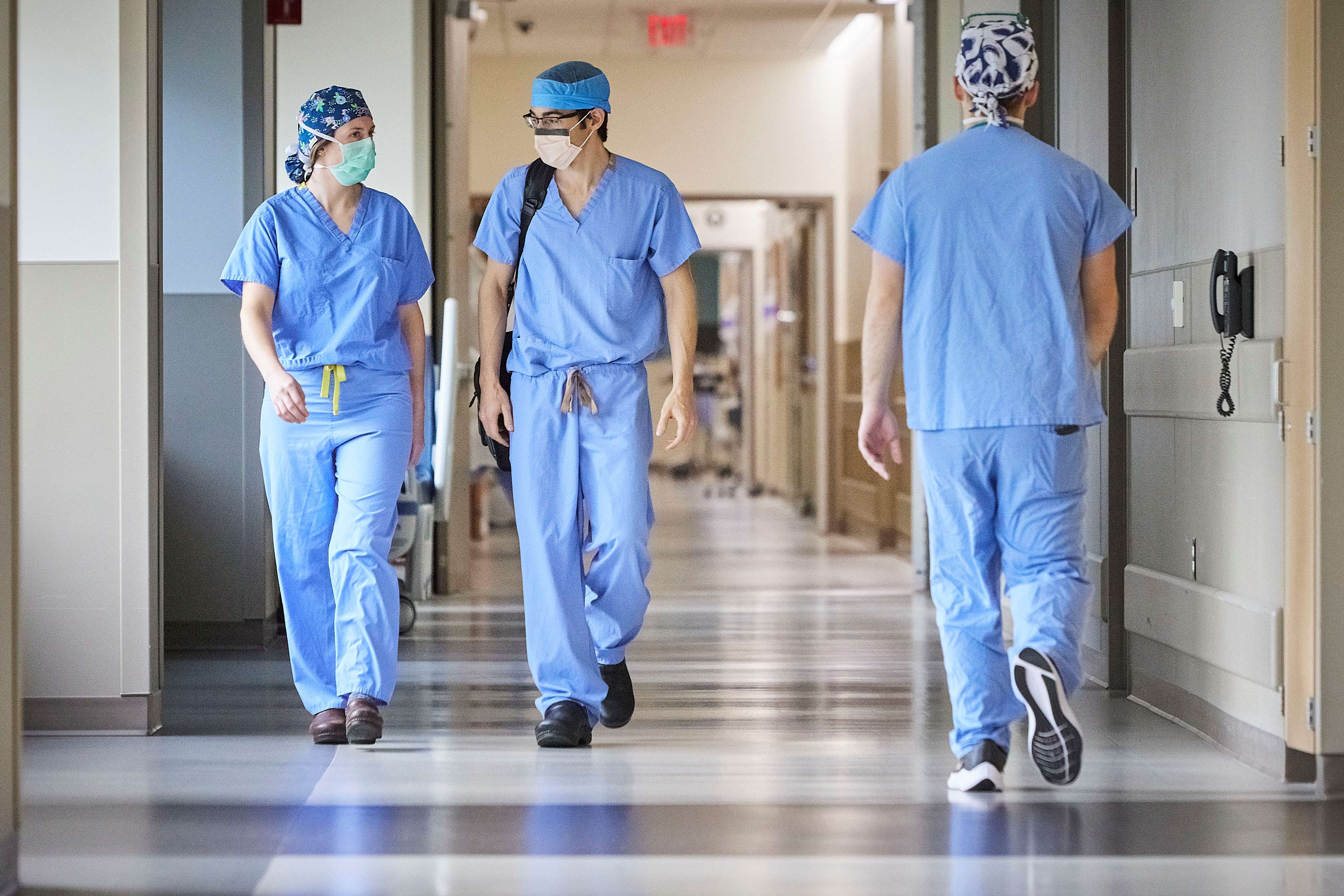 medical providers in scrubs walking in hallway