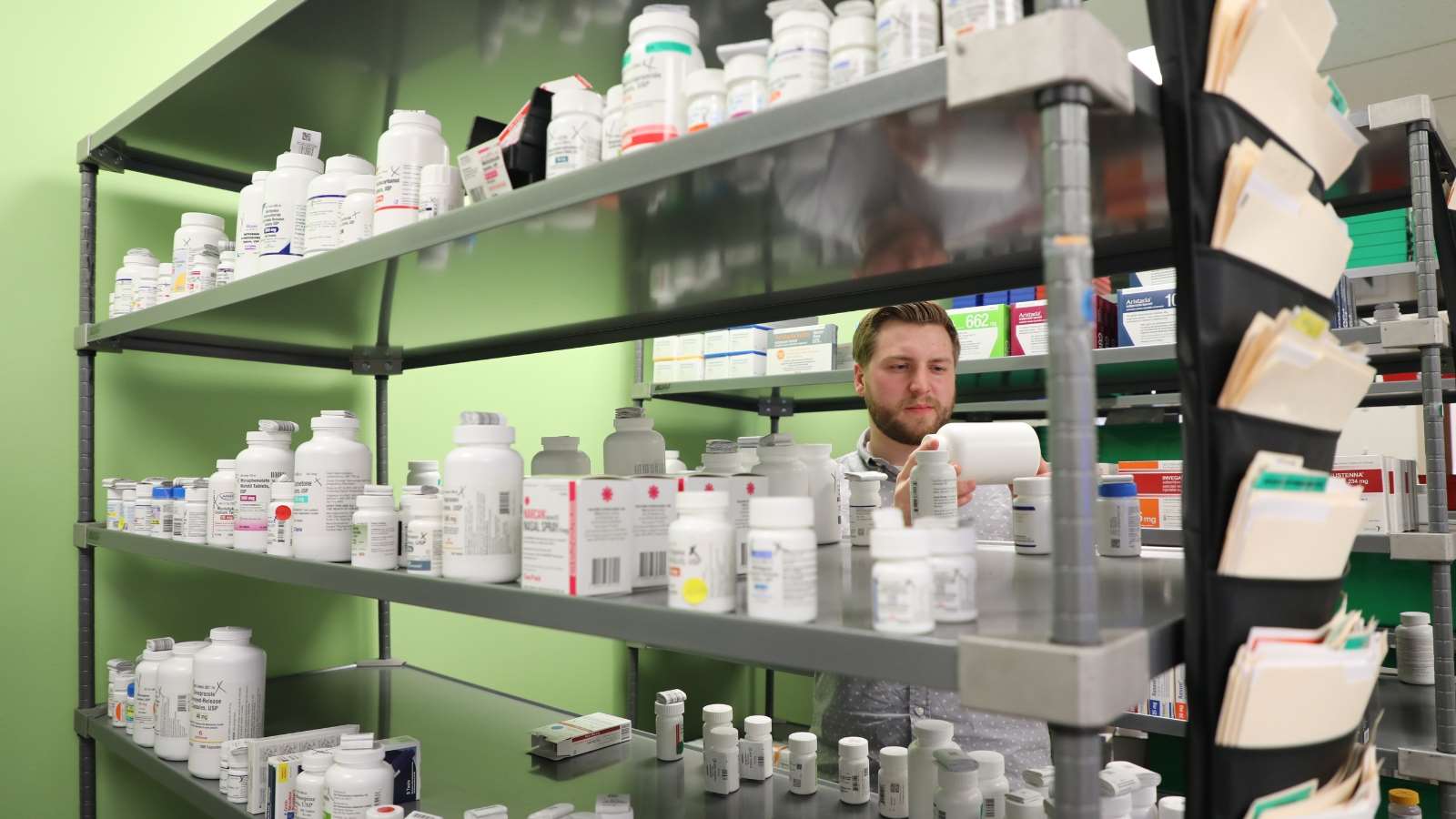 Resident takes inventory of medications at a pharmacy.